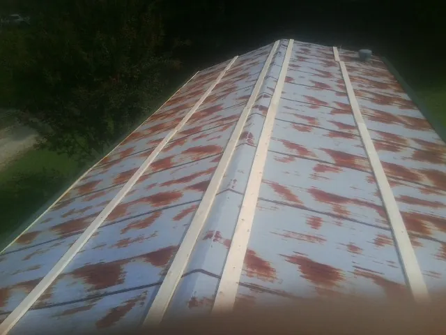 Rusted metal roof panels with new wood purlins before replacement — Storm Damage Roof Repair in Sidney by Roofing Brothers